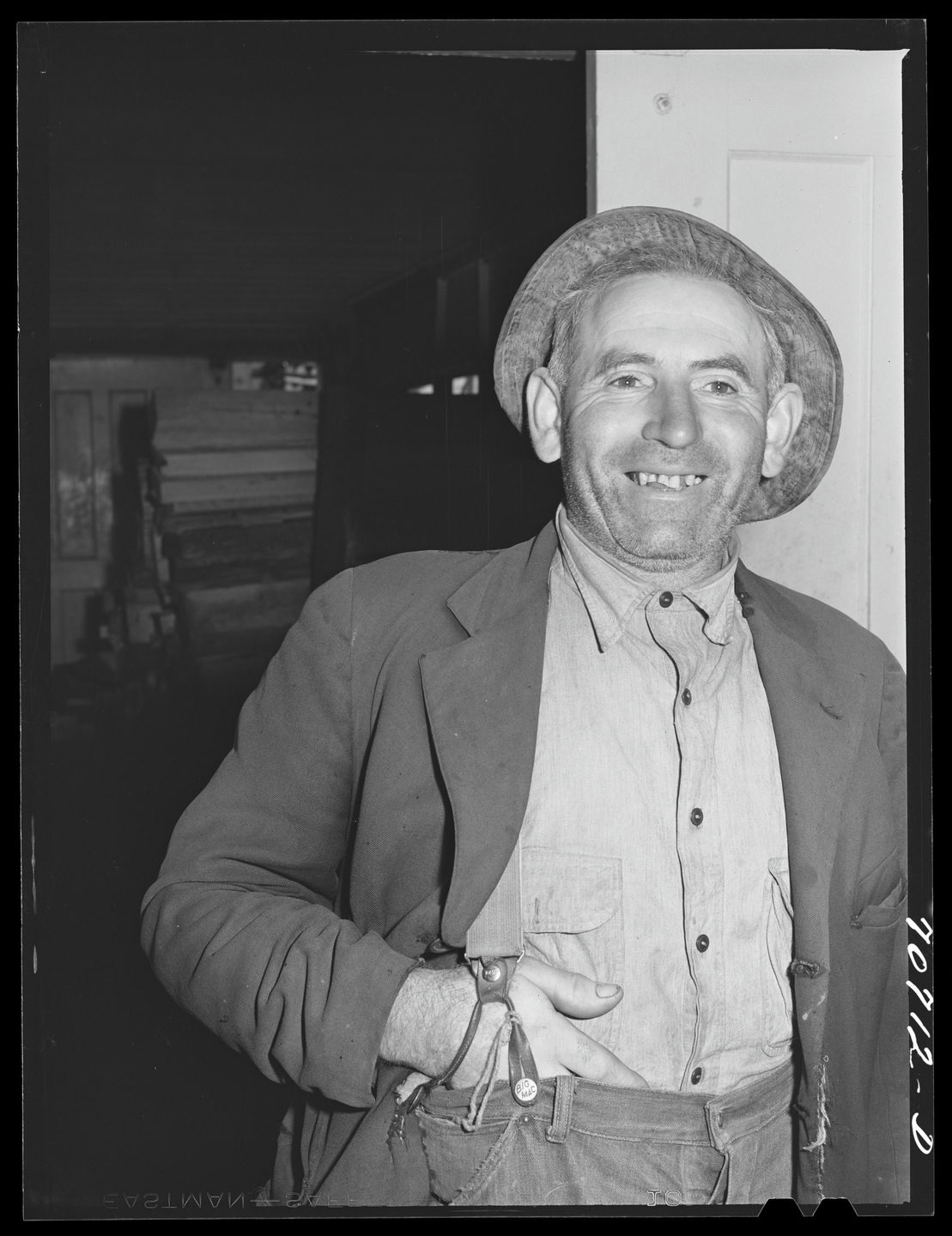 A farmer smiling in the doorway at the Tillamook cheese plant in 1941.