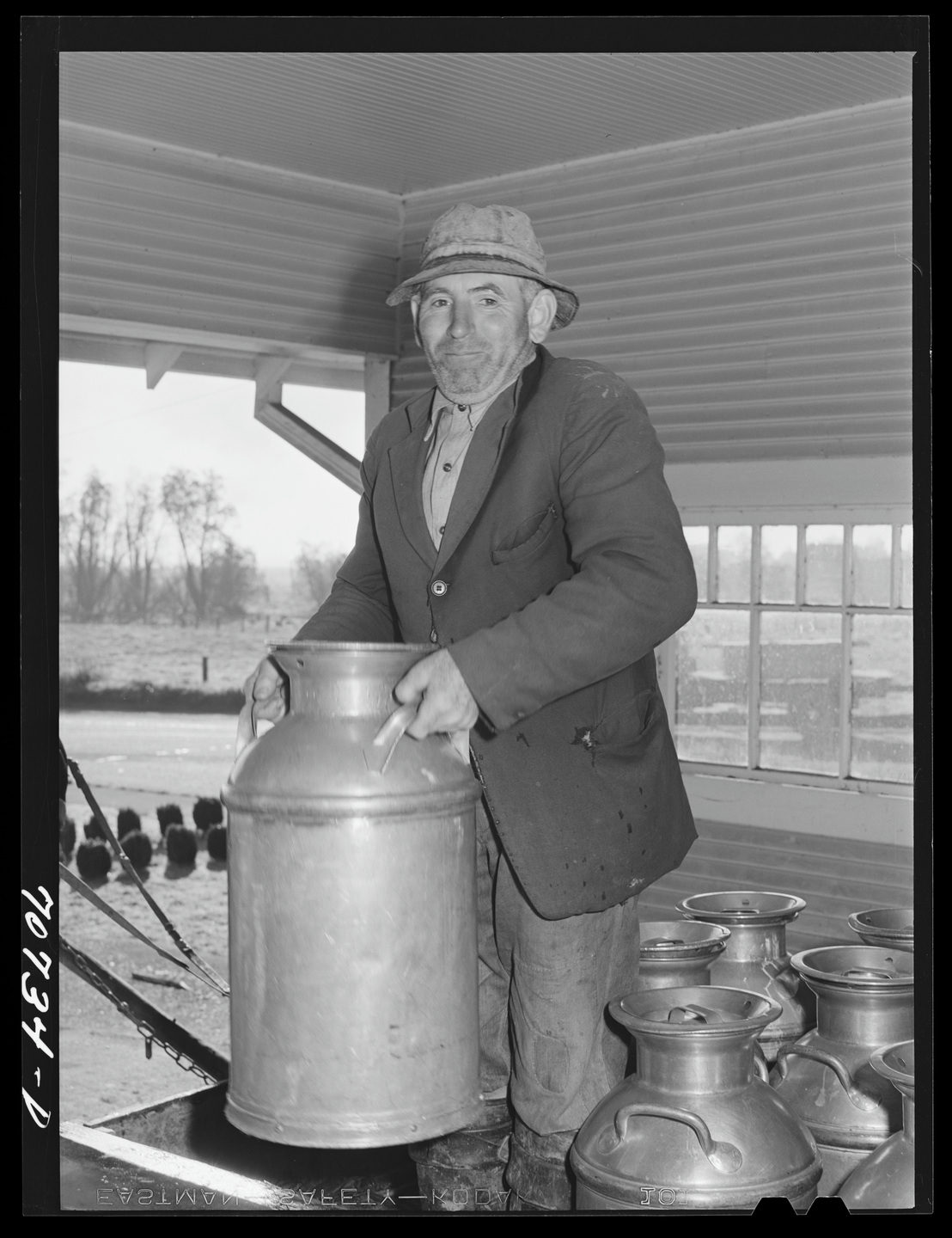 A dairy farmer holding a milk can at the Tillamook cheese plant in 1941.