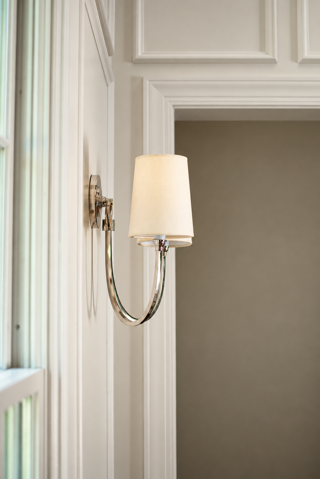 A brass light against a paneled wall. Flowers